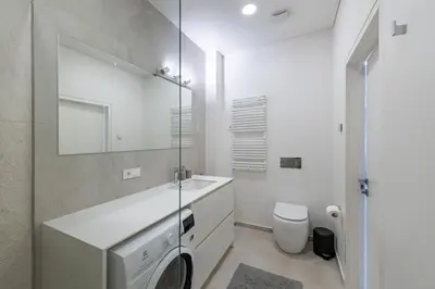 a bathroom with a sink and a toilet and a mirror at Spaciuos 1 BD Apt by Domvia in Kaunas