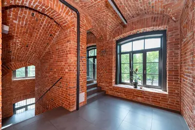 an empty room with a brick wall and windows at Spaciuos 1 BD Apt by Domvia in Kaunas