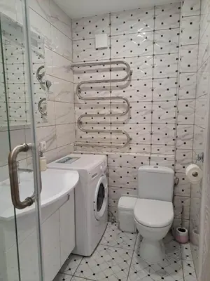 a bathroom with a toilet a sink and a washing machine at Trumpalaikė apartamentų nuoma centre (Vytauto g.) in Šiauliai