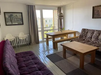 a living room with a couch and a table at Butas Anykščiuose šeimoms in Anykščiai