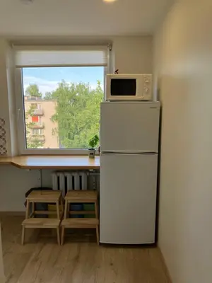 a kitchen with a white refrigerator and a microwave at Butas Anykščiuose šeimoms in Anykščiai