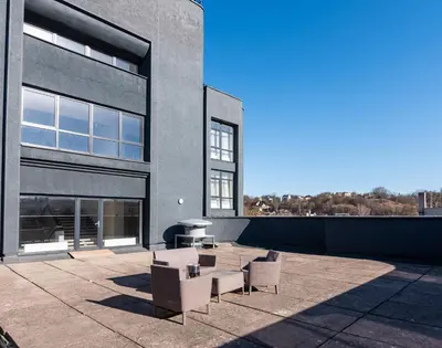 a patio with chairs and a table in front of a building at Kaunas apartments near Bus station in Kaunas