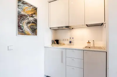 a kitchen with white cabinets and a sink at Kaunas apartments near Bus station in Kaunas