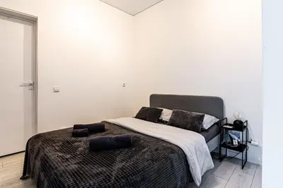 a bedroom with a bed with a blanket and pillows at Kaunas apartments near Bus station in Kaunas