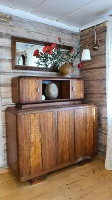 a wooden wall with a mirror and flowers on it at Authentic homestead over 100 years old in Kėdainiai