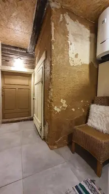 a room with a garage with a couch and a door at Authentic homestead over 100 years old in Kėdainiai