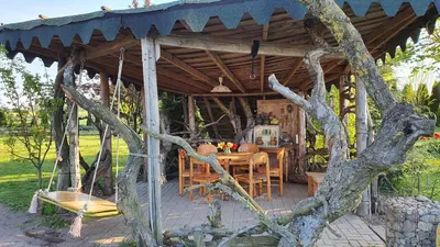 a wooden gazebo with a table and chairs at Authentic homestead over 100 years old in Kėdainiai