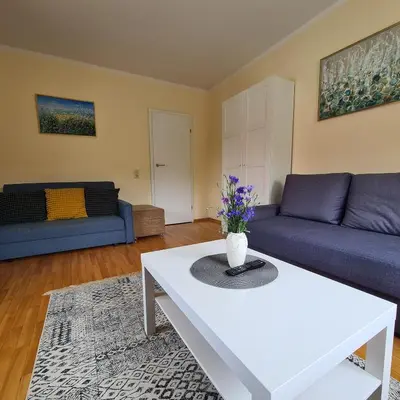 a living room with two blue couches and a white table at Apartamentai Luna in Druskininkai