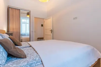a bedroom with a large white bed and a mirror at Picturesque Old Town Apartment with Charming Balcony in Kaunas