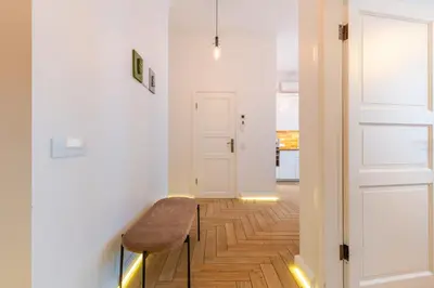 a hallway with a bench next to a door at Picturesque Old Town Apartment with Charming Balcony in Kaunas