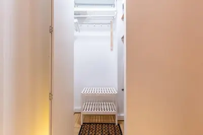 a closet with a white door with a shelf at Picturesque Old Town Apartment with Charming Balcony in Kaunas