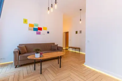 a living room with a couch and a table at Picturesque Old Town Apartment with Charming Balcony in Kaunas