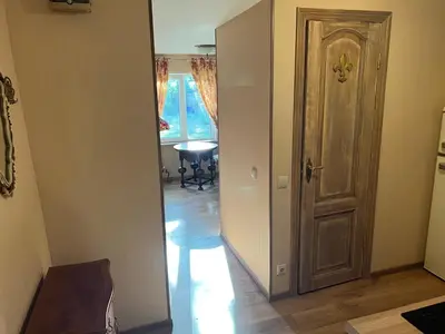 a hallway with a door and a dining room at Arbatinės apartamentai - Močiutės namelis in Biržai