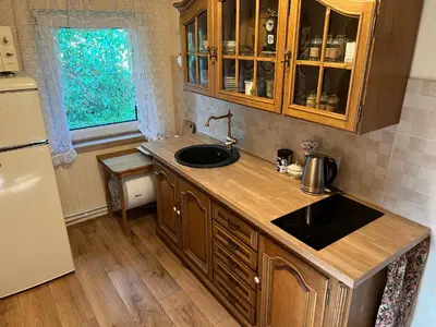 a kitchen with a sink and a refrigerator at Arbatinės apartamentai - Močiutės namelis in Biržai