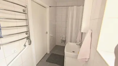 a white bathroom with a shower and a toilet at Vakaro Namai in Alytus