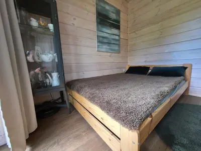 a bedroom with a bed in a wooden room at Obuoliu sala Moletu Vila in Gaylyunay