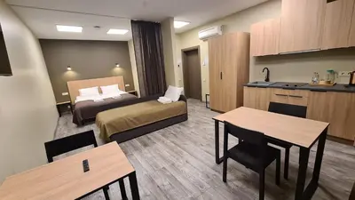 a hotel room with a bed and a kitchen at Airus Apartamentai in Anykščiai