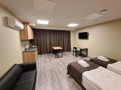 a hotel room with two beds and a television at Airus Apartamentai in Anykščiai