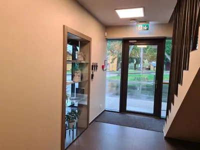 a hallway with a door leading into a building at Airus Apartamentai in Anykščiai