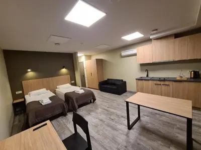a hotel room with two beds and a table at Airus Apartamentai in Anykščiai