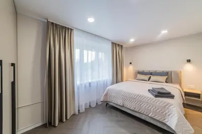 a bedroom with a bed and a large window at Frida Apartment in Šiauliai