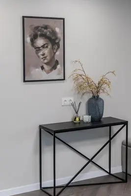 a black table in a room with a picture on the wall at Frida Apartment in Šiauliai
