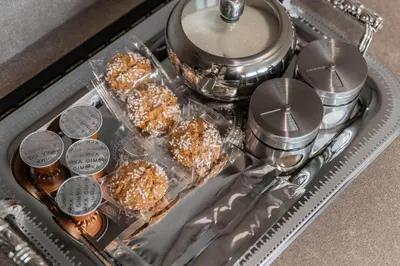a tray filled with donuts and spoons and a tray of food at Frida Apartment in Šiauliai