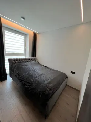 a bedroom with a bed in a room with a window at J.Kairiūkščio apartamentai in Vilnius