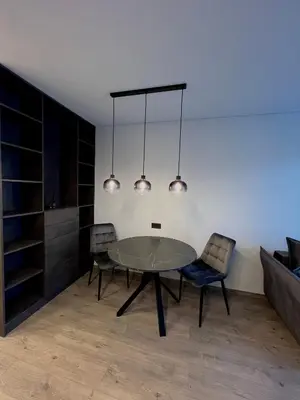 a dining room with a glass table and two chairs at J.Kairiūkščio apartamentai in Vilnius