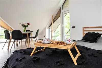 a living room with a table and a dining room at Rytas cozy apartment in the guest house with the terrace and the stunning view to the river side in Birštonas