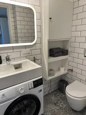 a bathroom with a washing machine and a sink at M Loft2 in Kaunas