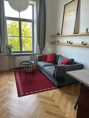 a living room with a couch and a red rug at M Loft2 in Kaunas