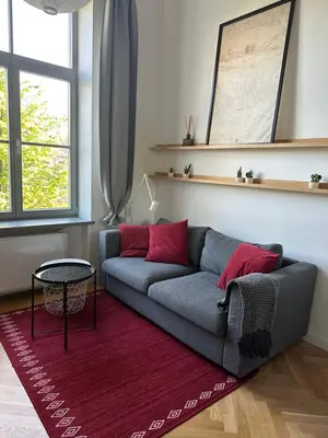 a living room with a couch and a red rug at M Loft2 in Kaunas
