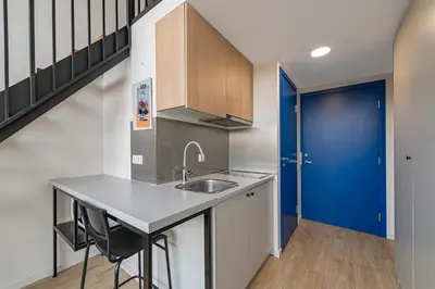 a kitchen with a sink and a blue door at Mini Loft 1 BD Apt by Domvia in Kaunas