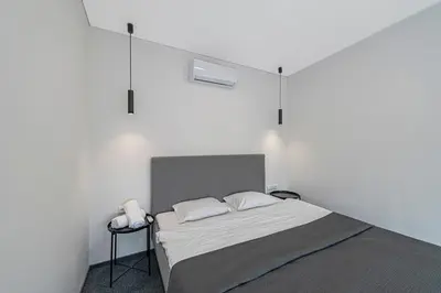 a white room with a bed with two pillows at Mini Loft 1 BD Apt by Domvia in Kaunas