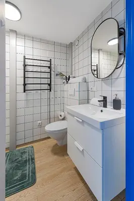 a bathroom with a sink and a toilet and a mirror at Mini Loft 1 BD Apt by Domvia in Kaunas