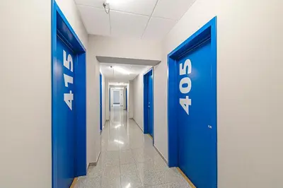 a corridor with blue doors in a hallway at Mini Loft 1 BD Apt by Domvia in Kaunas