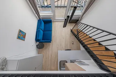 an office with a blue chair and a staircase at Mini Loft 1 BD Apt by Domvia in Kaunas