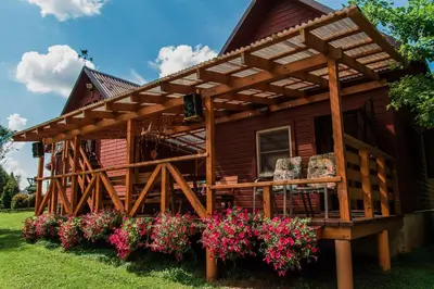 a log cabin with flowers in front of it at Taparynė in Alanta