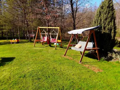 two swings and a bench in a park at Taparynė in Alanta