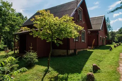 a house with a tree in front of it at Taparynė in Alanta