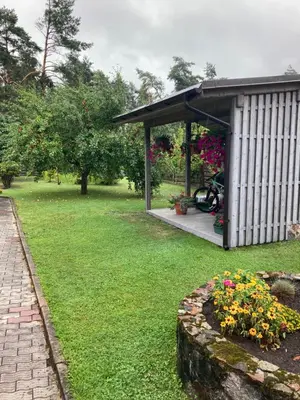 a garden with a pavilion and flowers in a yard at Pušyno Apartments-Studio in Anykščiai