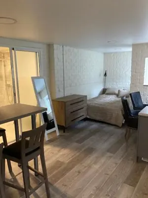 a bedroom with a bed and a desk and a table at Pušyno Apartments-Studio in Anykščiai