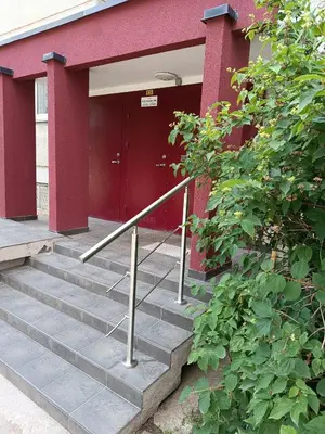 a red building with stairs leading to a red door at Lovely Stay in Siauliai in Šiauliai