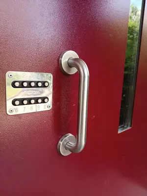 a metal door handle on a red door at Lovely Stay in Siauliai in Šiauliai