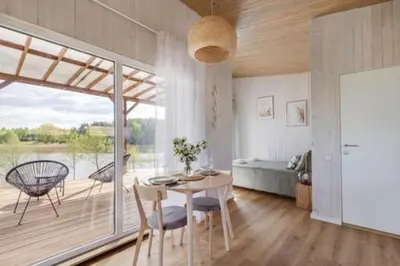 a living room with a table and chairs and a bedroom at Pineplace twins Smilga in Žaugėdai