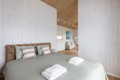a bedroom with a bed with two towels on it at Pineplace twins Smilga in Žaugėdai