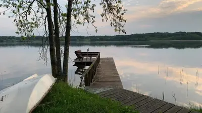 a dock on a lake with a boat on it at Poilsis ant Virintų ežero kranto in Molėtai