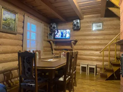 a dining room with a table and a tv on a wall at Poilsis ant Virintų ežero kranto in Molėtai