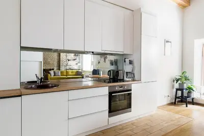 a kitchen with white cabinets and a sink at Cozy studio apartment central in Vilnius